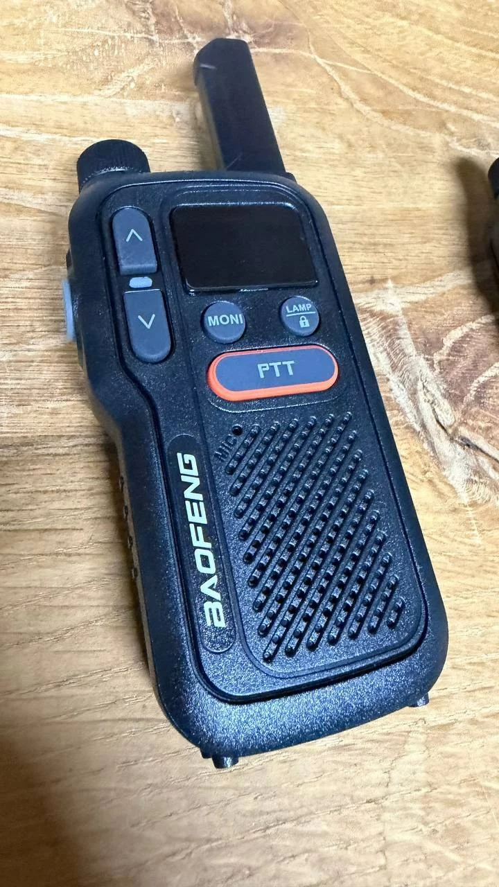 Talkie-walkie Baofeng BF-T18 vu de face, avec son écran, les touches MONI et LAMP et le bouton PTT orange.