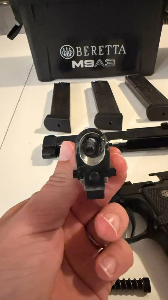 Canon du Beretta M9A3 tenu à la main, vu par la chambre, avec son bloc de verrouillage dessous.