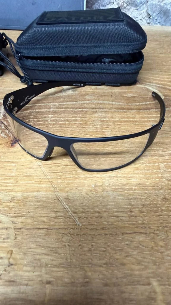 Lunettes Gatorz à verres clairs et monture noire mate devant leur étui zippé noir.