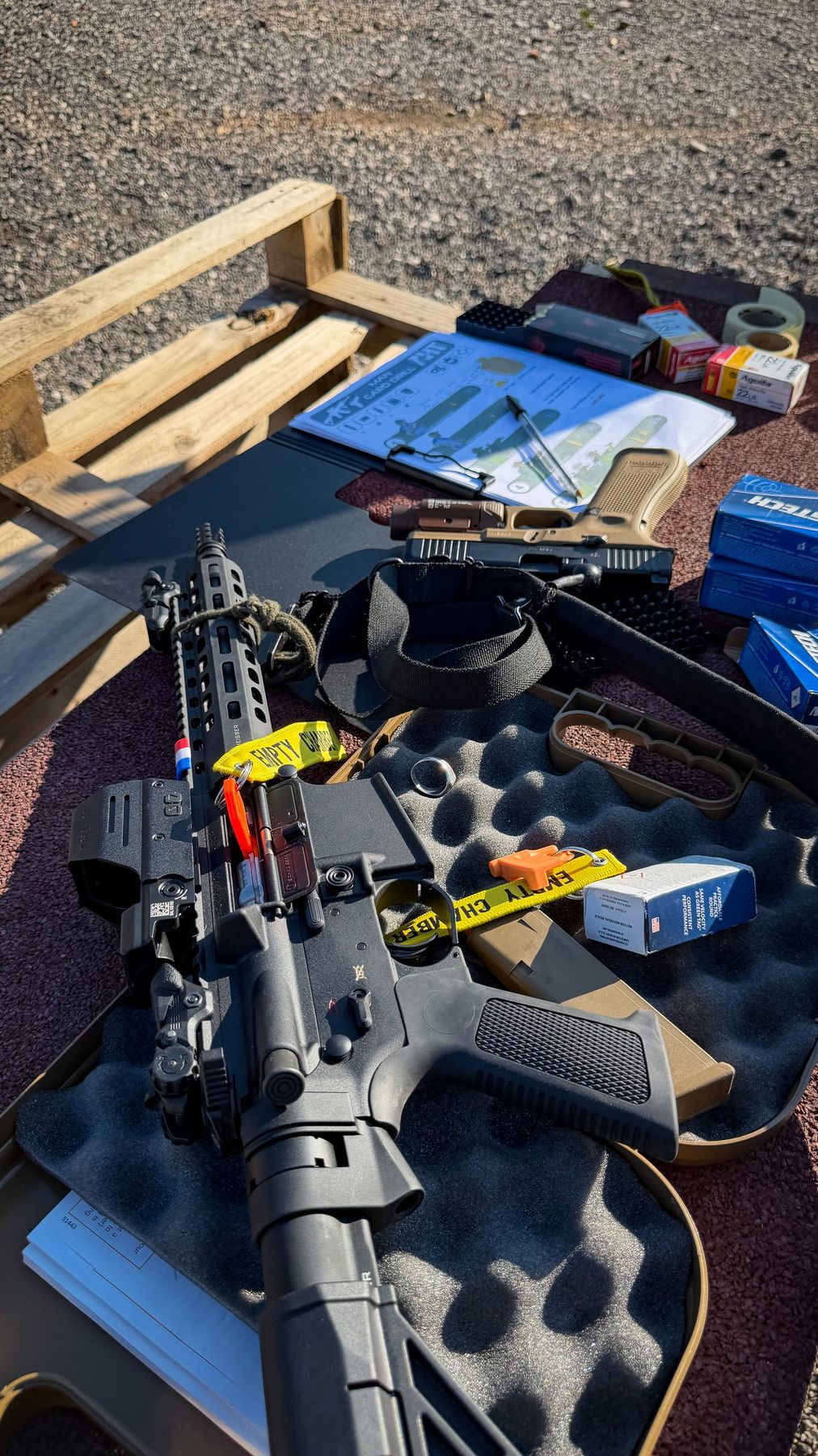 AR-15 avec point rouge et grossisseur dans sa mallette, drapeau de chambre en place