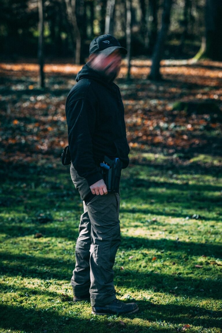 En forêt, ceinture équipée et arme de poing à la hanche